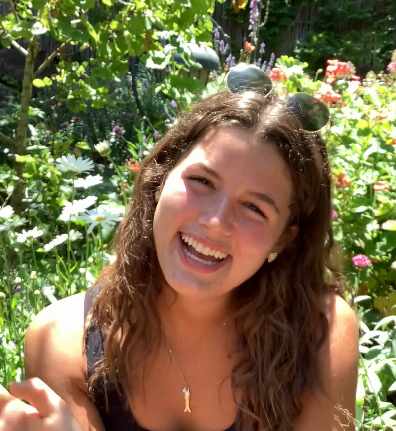 A smiling woman sitting in a garden