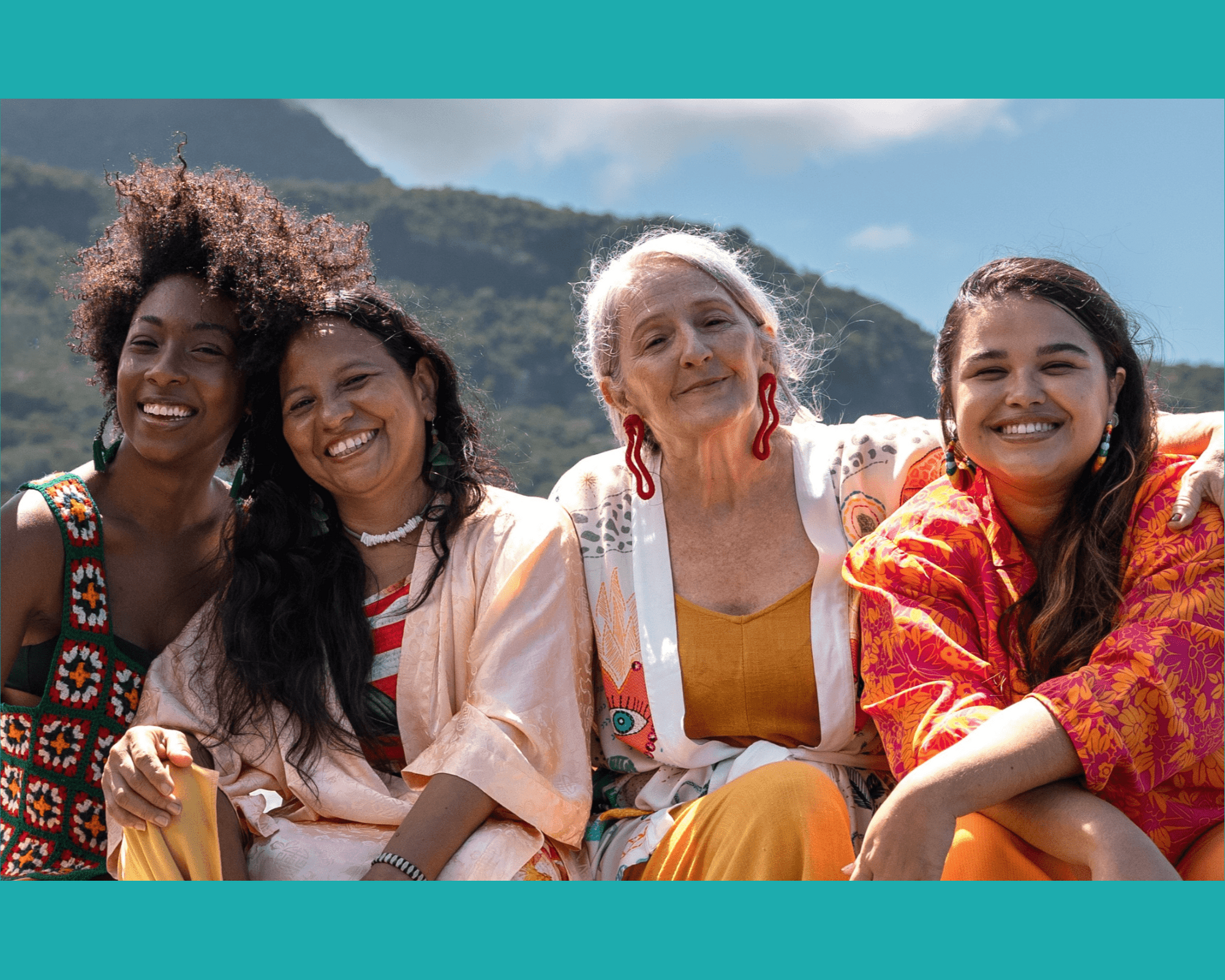 Smiling women from different generations sit together under a blue sky.