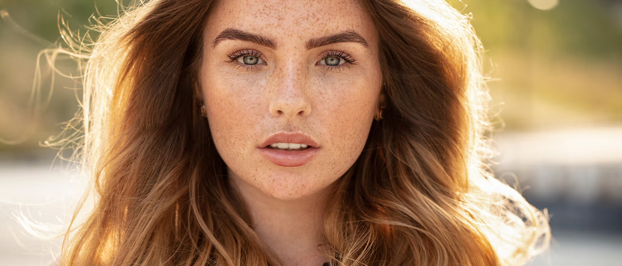 A woman with freckles standing in the sunlight
